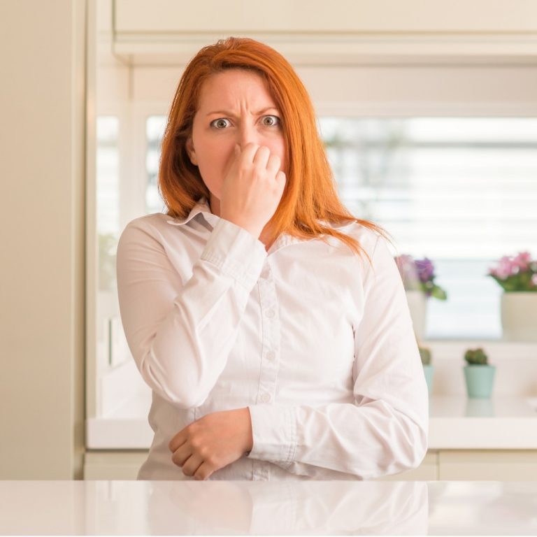 Redhead Woman At Kitchen Smelling Something Stinky And Disgusting
